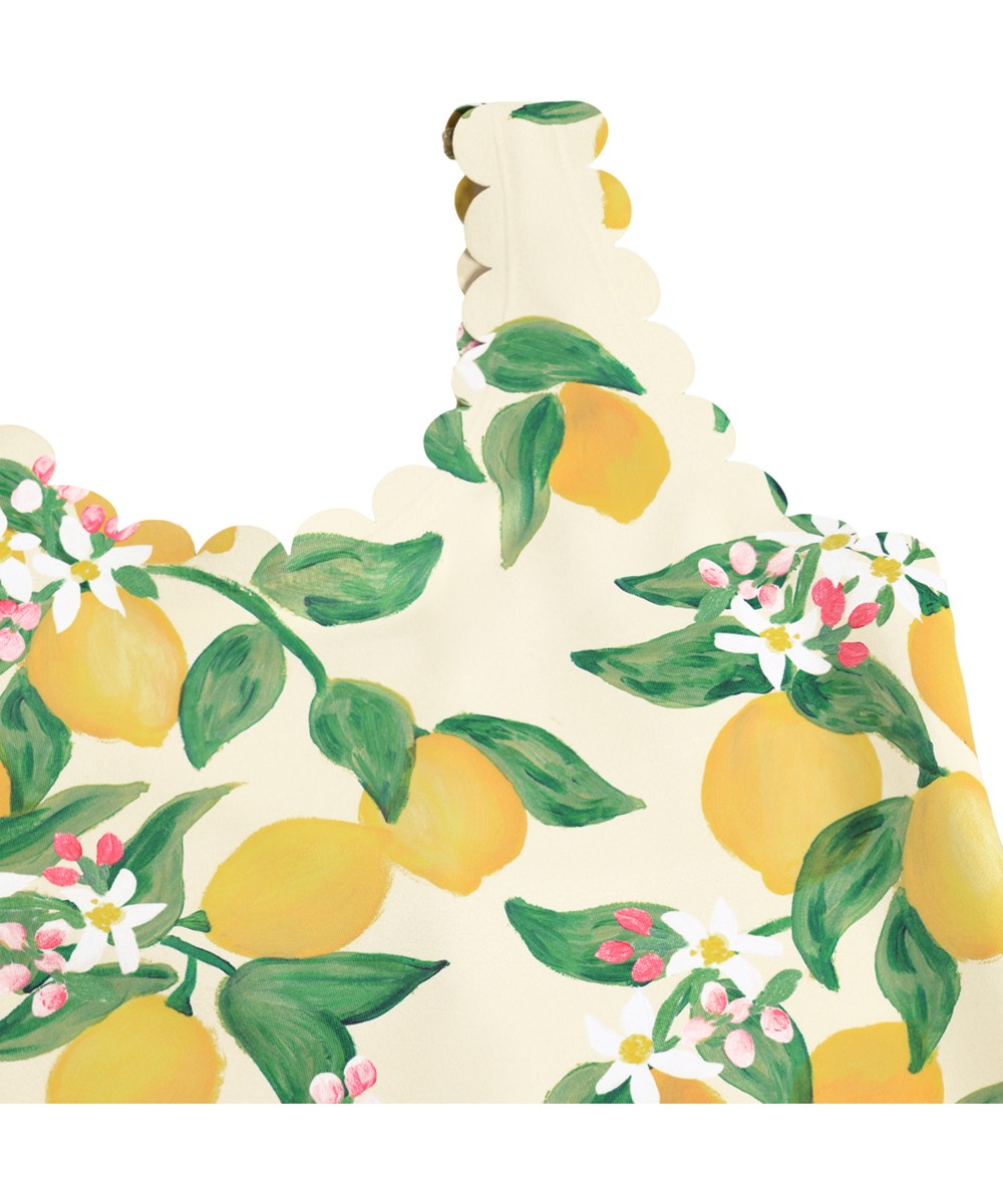 Noelle - Citrus - Gelber Badeanzug mit Wellenkanten und Zitrusdruck für Kinder aus recyceltem Polyester mit UV-Schutz 50+.