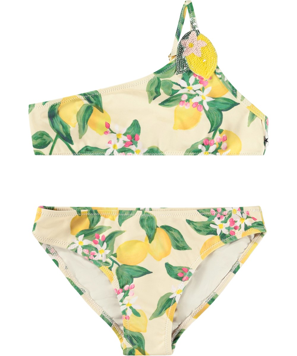 Naja - Citrus - Gul, asymmetrisk bikini med citrusprint til børn i genanvendt polyester med UV-beskyttelse 50+.