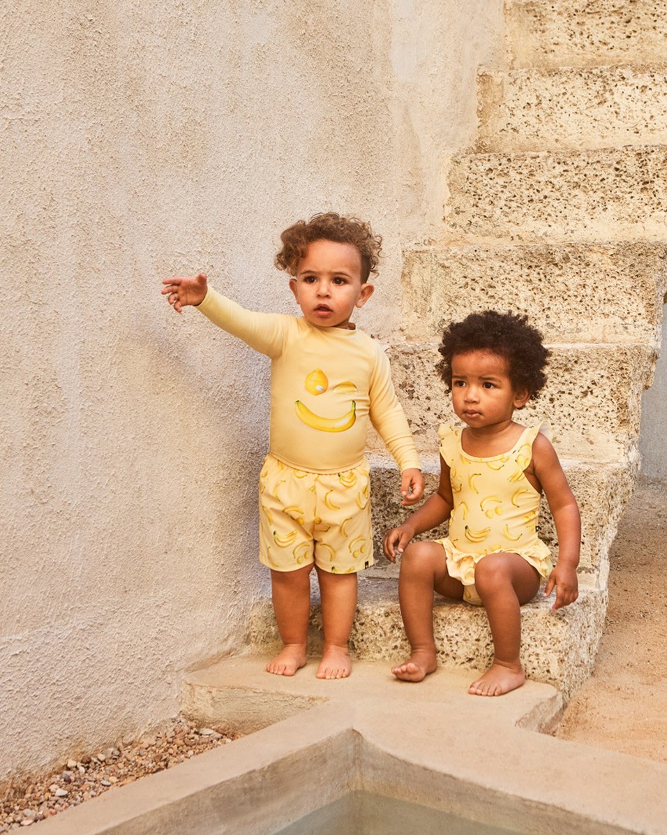 Nalani - Lemon Banana - Gul babybadedragt med frugtprint i genanvendt polyester med UV-beskyttelse 50+.