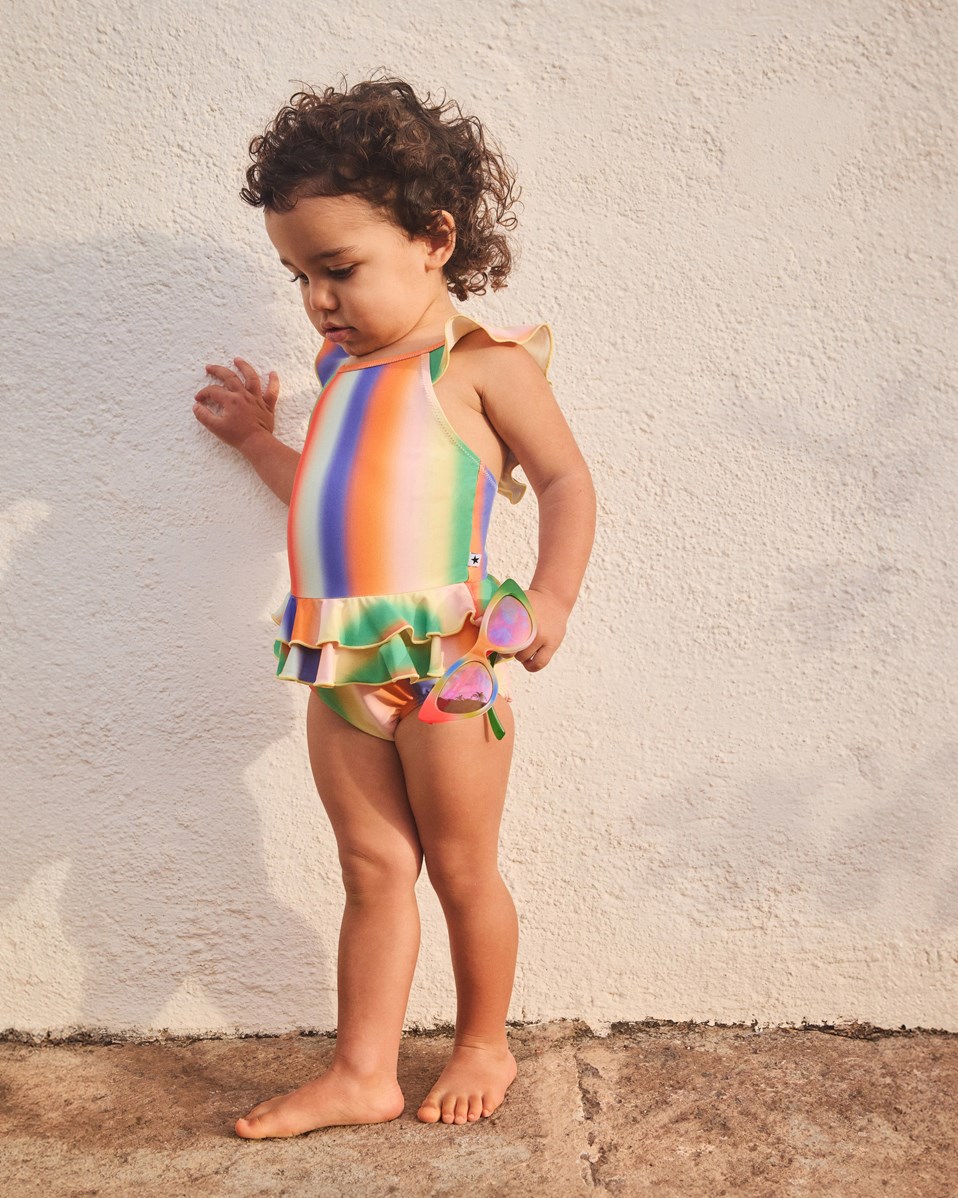 Nalani - Rainbow Light - Regnbuefarvet baby badedragt i genanvendt polyester med UV-beskyttelse 50+.