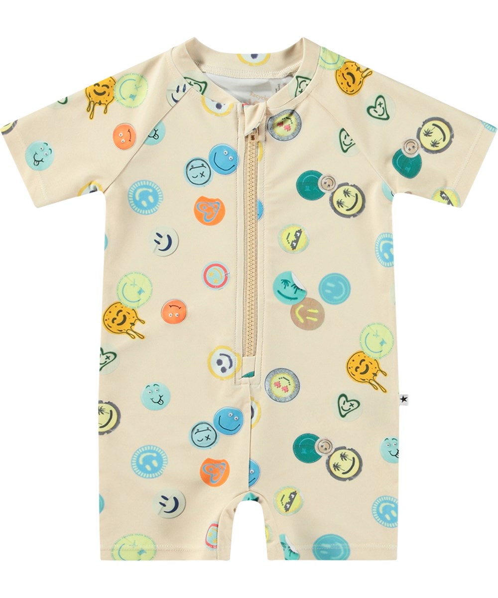 Neka - Sand Smile - Beige badedragt til børn med korte ærmer og ben i genanvendt polyester og UV-beskyttelse 50+.