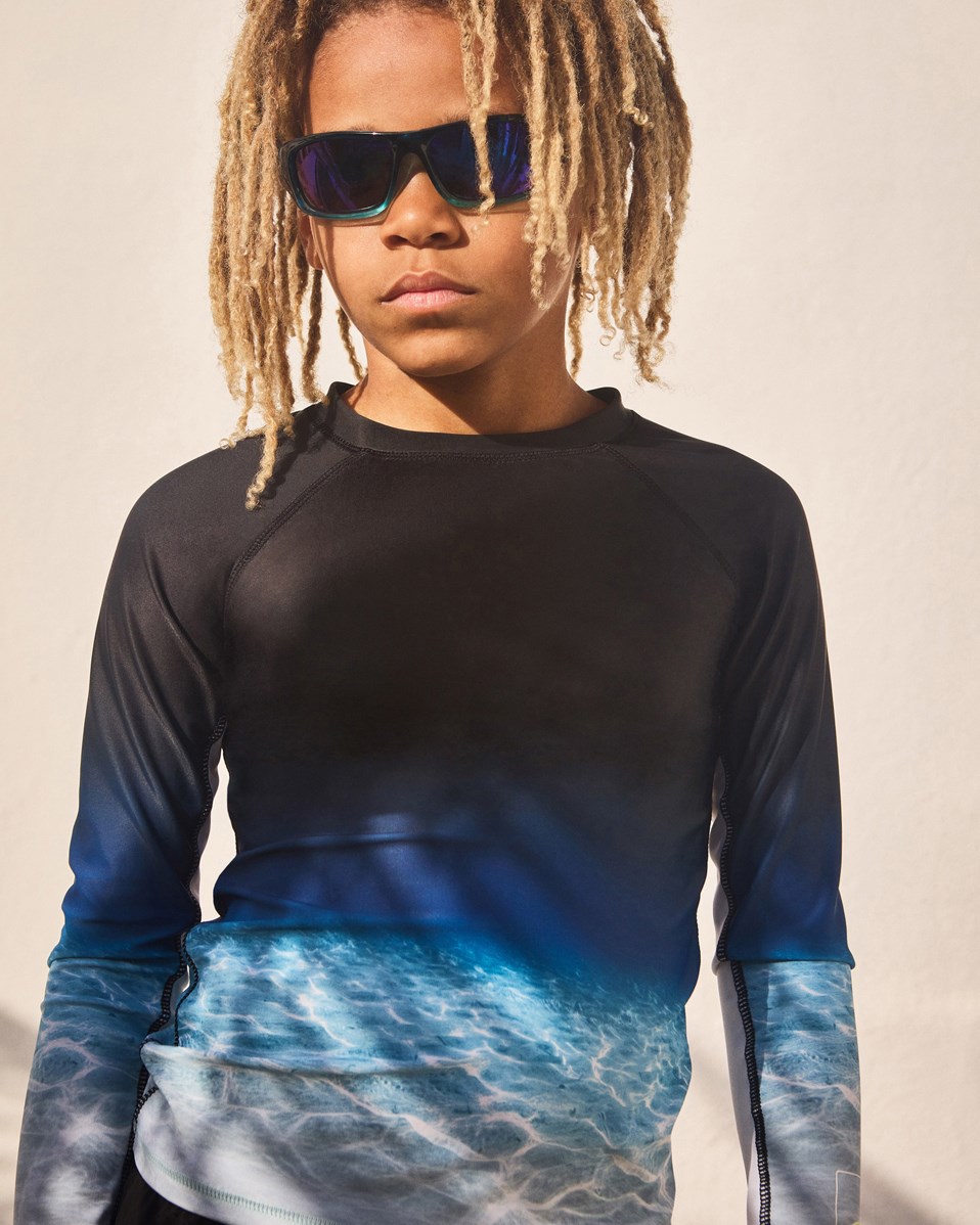 Neptune LS - Faded Ocean - Sort badebluse til aktive børn fremstillet i genanvendt polyester med UV-beskyttelse 50+. 