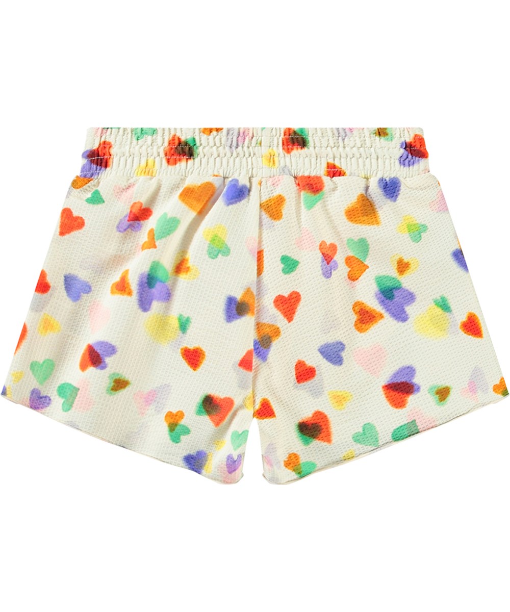 Nicci - Rainbow Hearts - Hvide badeshorts til aktive børn med UV-beskyttelse 50+ og et farverigt hjerte print