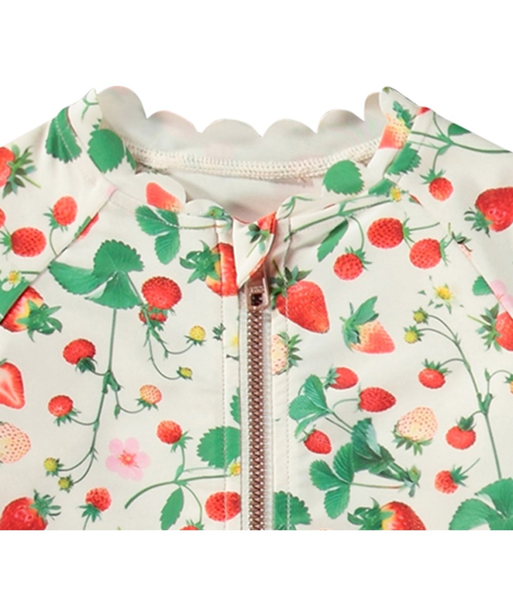 Nigella - Strawberry Field - Hvid badedragt til børn med lange ærmer og korte ben i genanvendt polyester og UV-beskyttelse 50+.
