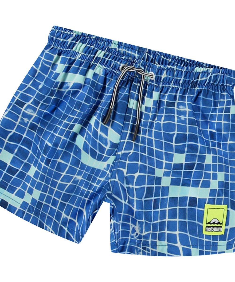 Niko - Tile Smile - Blå sporty badeshorts til aktive børn i genanvendt polyester med UV-beskyttelse 50+.