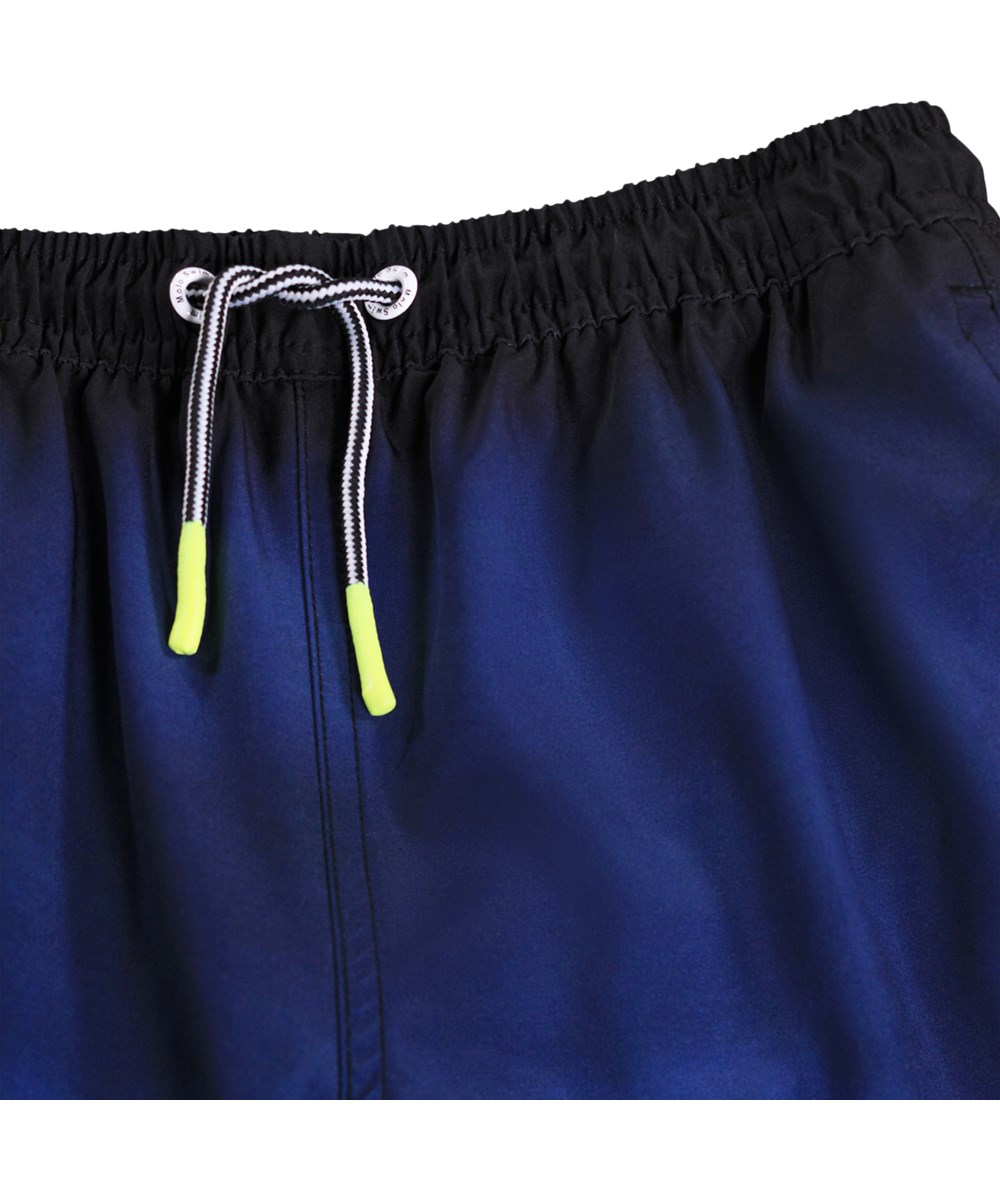 Nilson - Big Ocean - Blå, knælange badeshorts med havprint til børn i genanvendt polyester med UV-beskyttelse 50+.