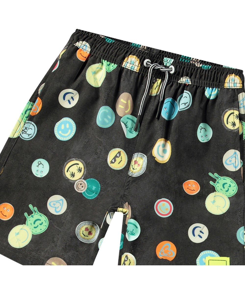 Nilson - Smile All Over - Knælange sorte badeshorts til aktive børn i genanvendt polyester med UV-beskyttelse 50+.