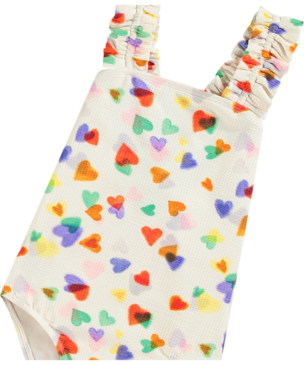 Nitika - Rainbow Hearts - Hvid badedragt til aktive børn i genanvendt polyester med UV-beskyttelse 50+.