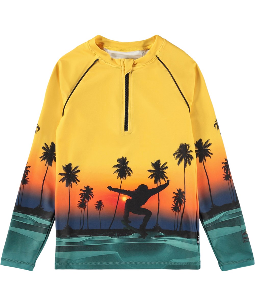 Noble - Sunset Skate - Gul badebluse med skateprint og lynlås til børn fremstillet i genanvendt polyester med UV-beskyttelse 50+.