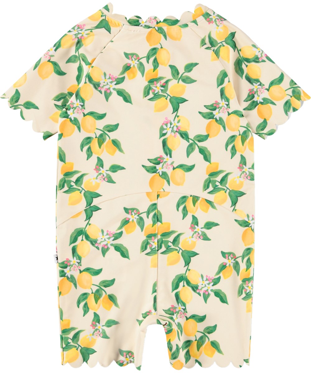 Nolu - Mini Citrus - Gul badedragt med citrusprint til baby og børn med korte ærmer og ben i genanvendt polyester og UV-beskyttelse 50+.