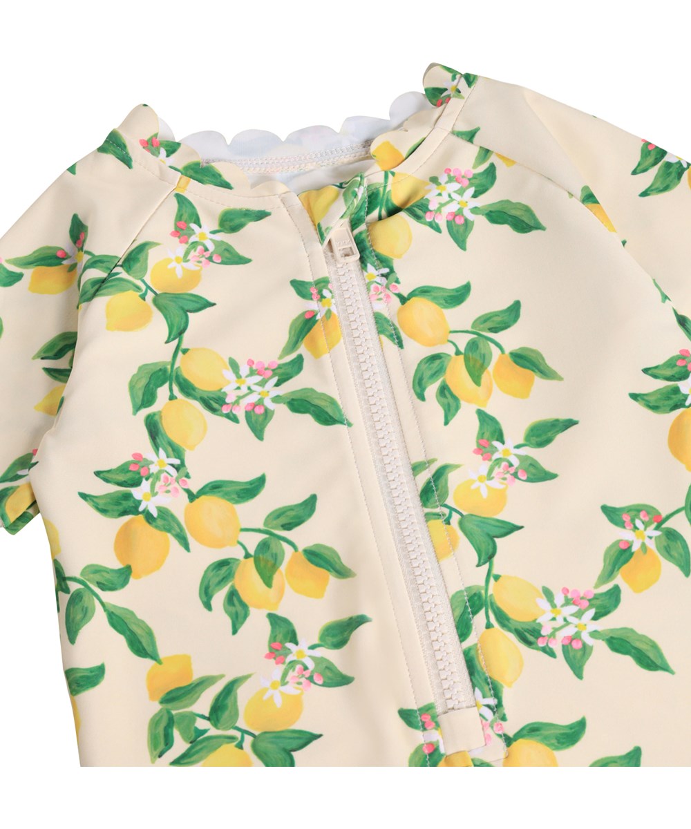 Nolu - Mini Citrus - Gul badedragt med citrusprint til baby og børn med korte ærmer og ben i genanvendt polyester og UV-beskyttelse 50+.
