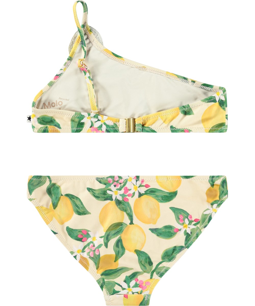Naja - Citrus - Gul, asymmetrisk bikini för barn med citrusmönster i återvunnen polyester med UV-skydd 50+.