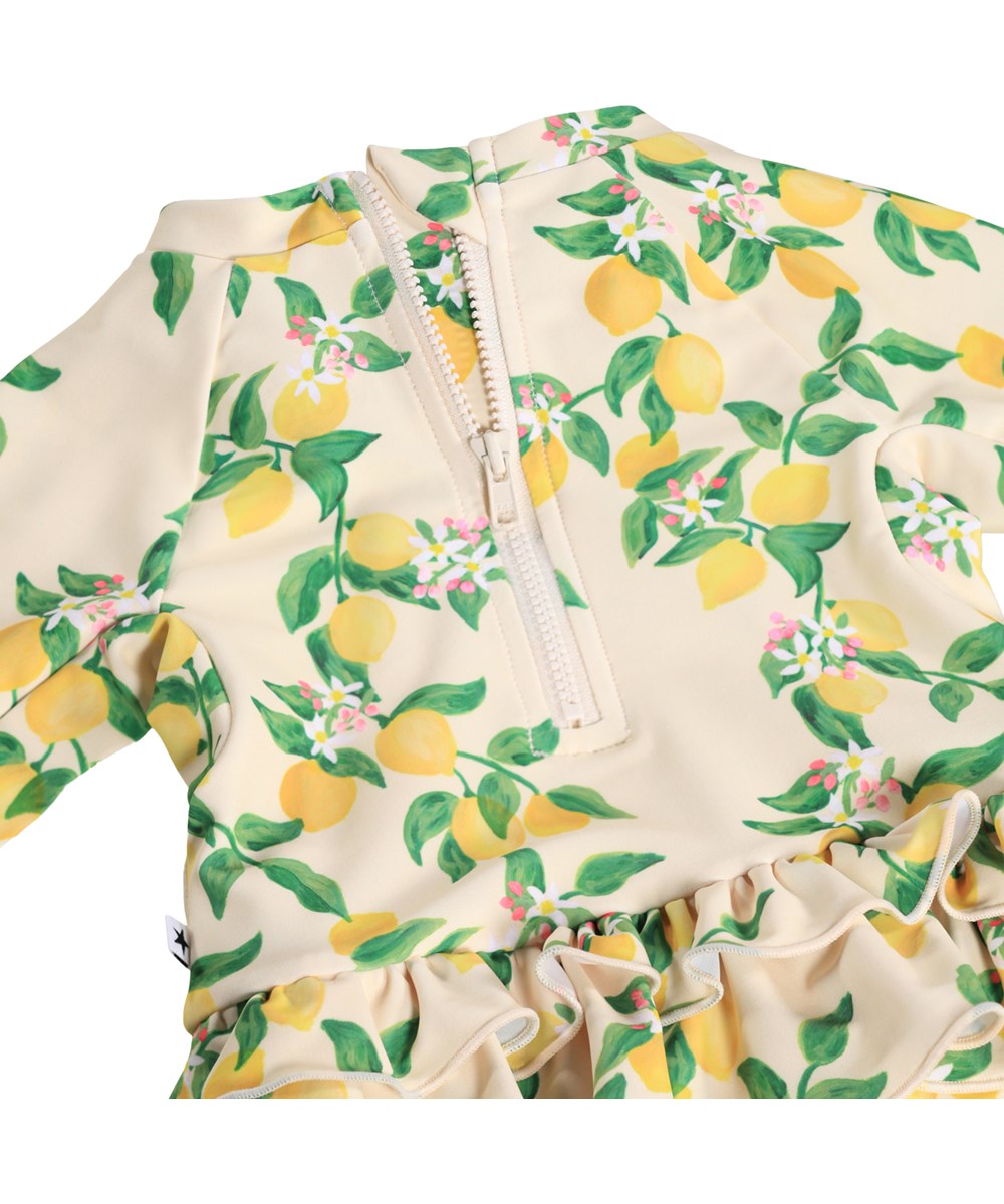 Narice - Mini Citrus - Gul, långärmad baddräkt för bebis med citrusmönster i återvunnen polyester med UV-skydd 50+.