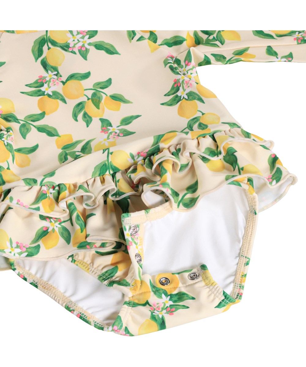 Narice - Mini Citrus - Gul, långärmad baddräkt för bebis med citrusmönster i återvunnen polyester med UV-skydd 50+.
