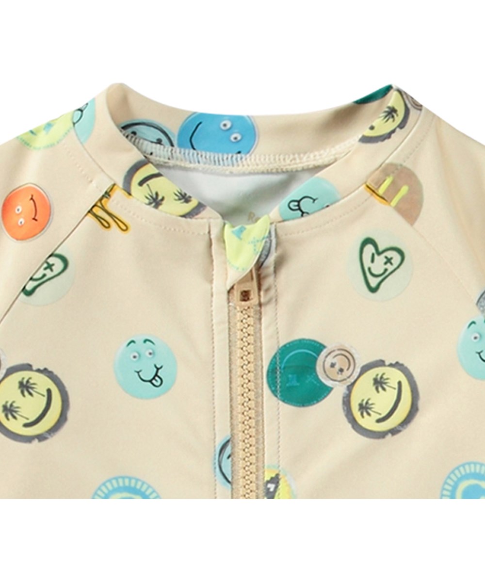Neka LS - Sand Smile - Beige baddräkt för barn med långa ärmar och korta ben i återvunnen polyester och UV-skydd 50+.