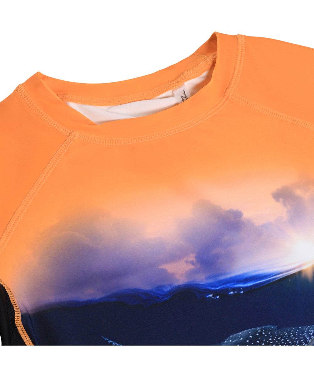 Neptune - Into The Sunset - Orange och blå simtröja för barn med havsmönster i återvunnen polyester med UV-skydd 50+.