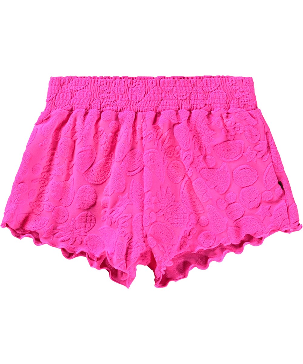 Nicci - Fruity Terry - Rosa badshorts för aktiva barn med UV-skydd 50+ och ett mönster av exotiska frukter.