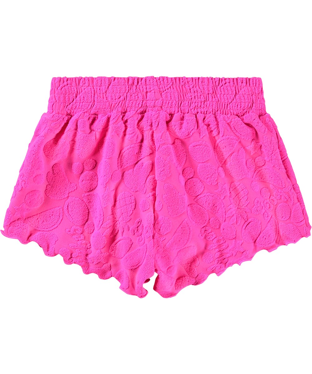 Nicci - Fruity Terry - Rosa badshorts för aktiva barn med UV-skydd 50+ och ett mönster av exotiska frukter.