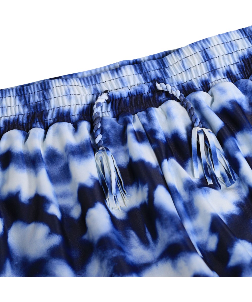 Nicci - Water - Blå batikfärgade badshorts för barn i återvunnen polyester med UV-skydd 50+.