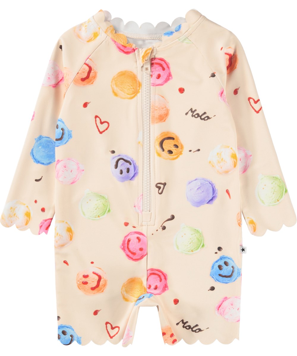 Nigella - Smile Scoops - Gräddfärgad baddräkt med glassmönster för de små med långa ärmar och korta ben i återvunnen polyester med UV-skydd 50+.