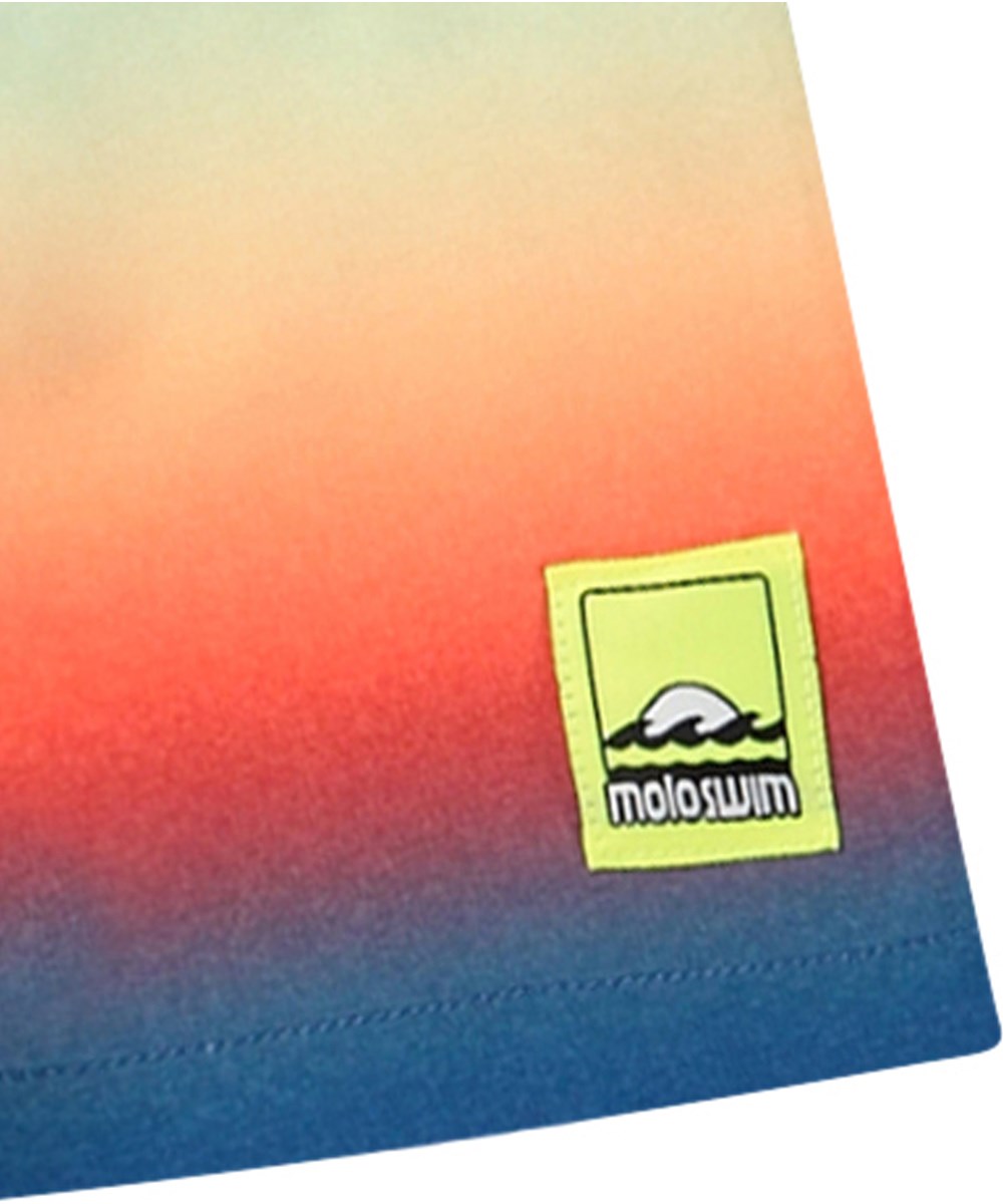 Niko - Blue Fade - Regnbågsfärgade sportiga badshorts för aktiva barn i återvunnen polyester med UV-skydd 50+.