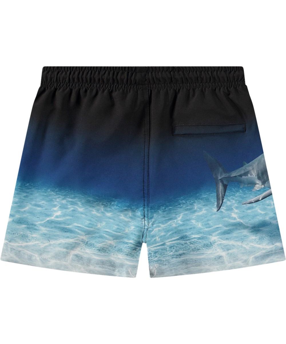 Niko - Faded Shark - Sportiga svarta och blå badshorts för aktiva barn i återvunnen polyester med UV-skydd 50+.