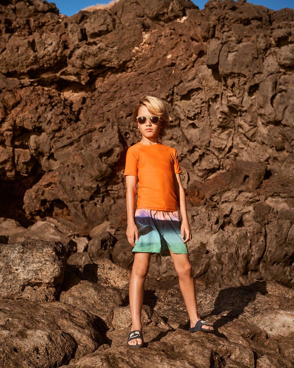 Niko - Into The Sunset - Sportiga badshorts i blått och orange med havsmönster för aktiva barn i återvunnen polyester med UV-skydd 50+.