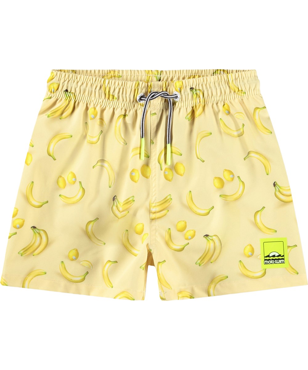 Niko - Lemon Banana - Sportiga, gula badshorts med fruktmönster för aktiva barn i återvunnen polyester med UV-skydd 50+.