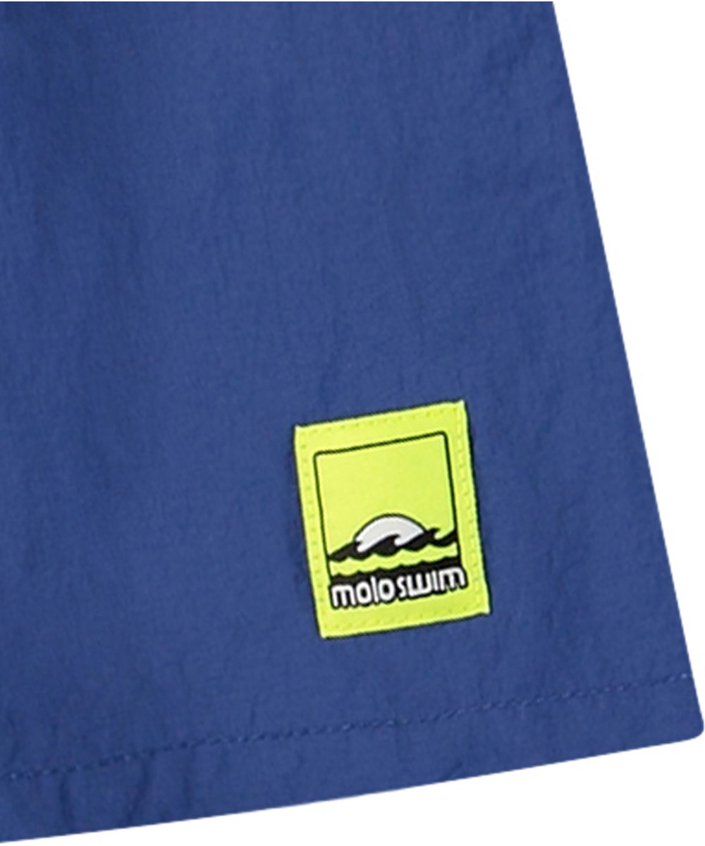 Niko Solid - Mazarine Blue - Sportiga blå badshorts för aktiva barn i återvunnen nylon med UV-skydd 50+.