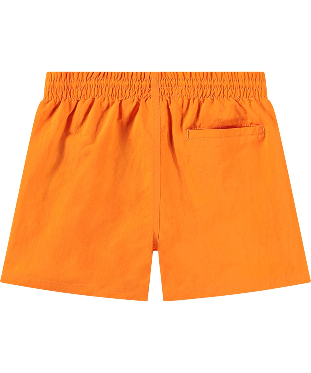 Niko Solid - Tumeric - Sportiga orange badshorts för aktiva barn i återvunnen nylon med UV-skydd 50+.