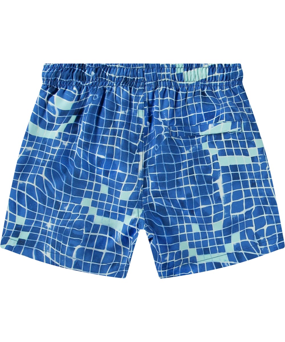 Niko - Tile Smile - Blå sportiga badshorts för aktiva barn i återvunnen polyester med UV-skydd 50+.