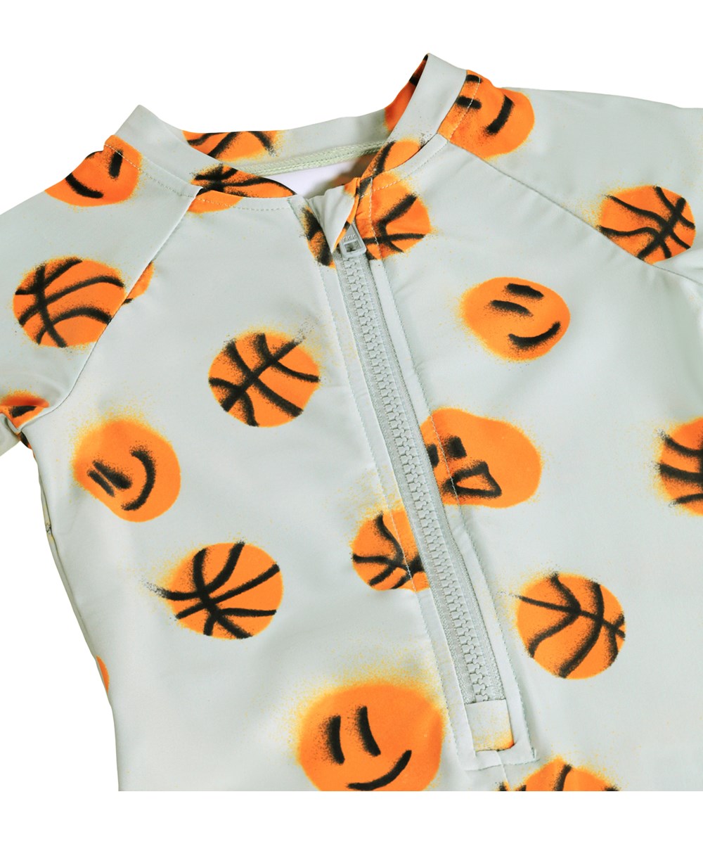 Neka LS - Mini Basket - Grijs badpak met basketbalprint voor de kleintjes met lange mouwen en korte pijpen, gemaakt van gerecycled polyester met UV-bescherming 50+.