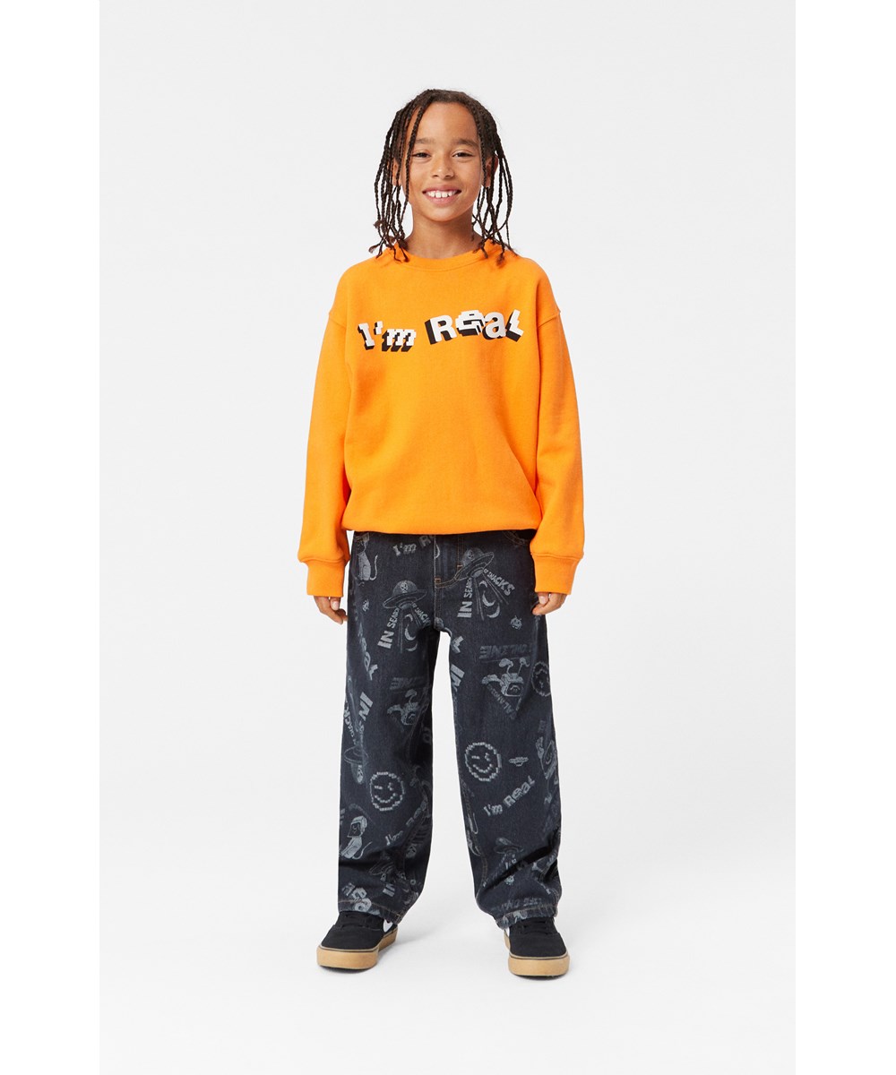 Aiden - Comic Jacquard - Svarta jeans med ett mönster av en vit seriefigur, lös passform.