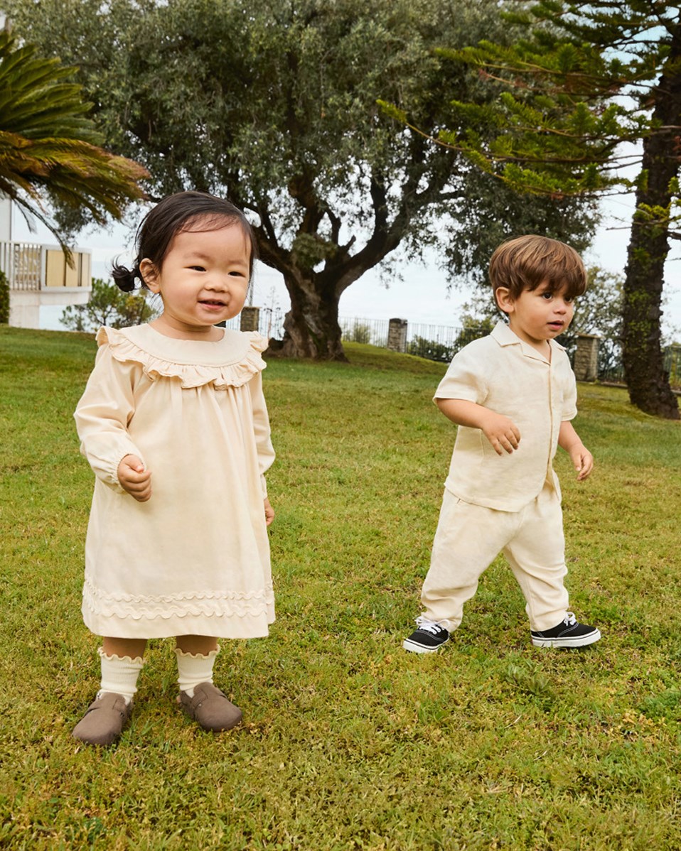 Sois - Summer Sand - Byxor i ekologisk bomull för baby. Byxorna är ljusbeige med en liten broderan smiley vid fickan.