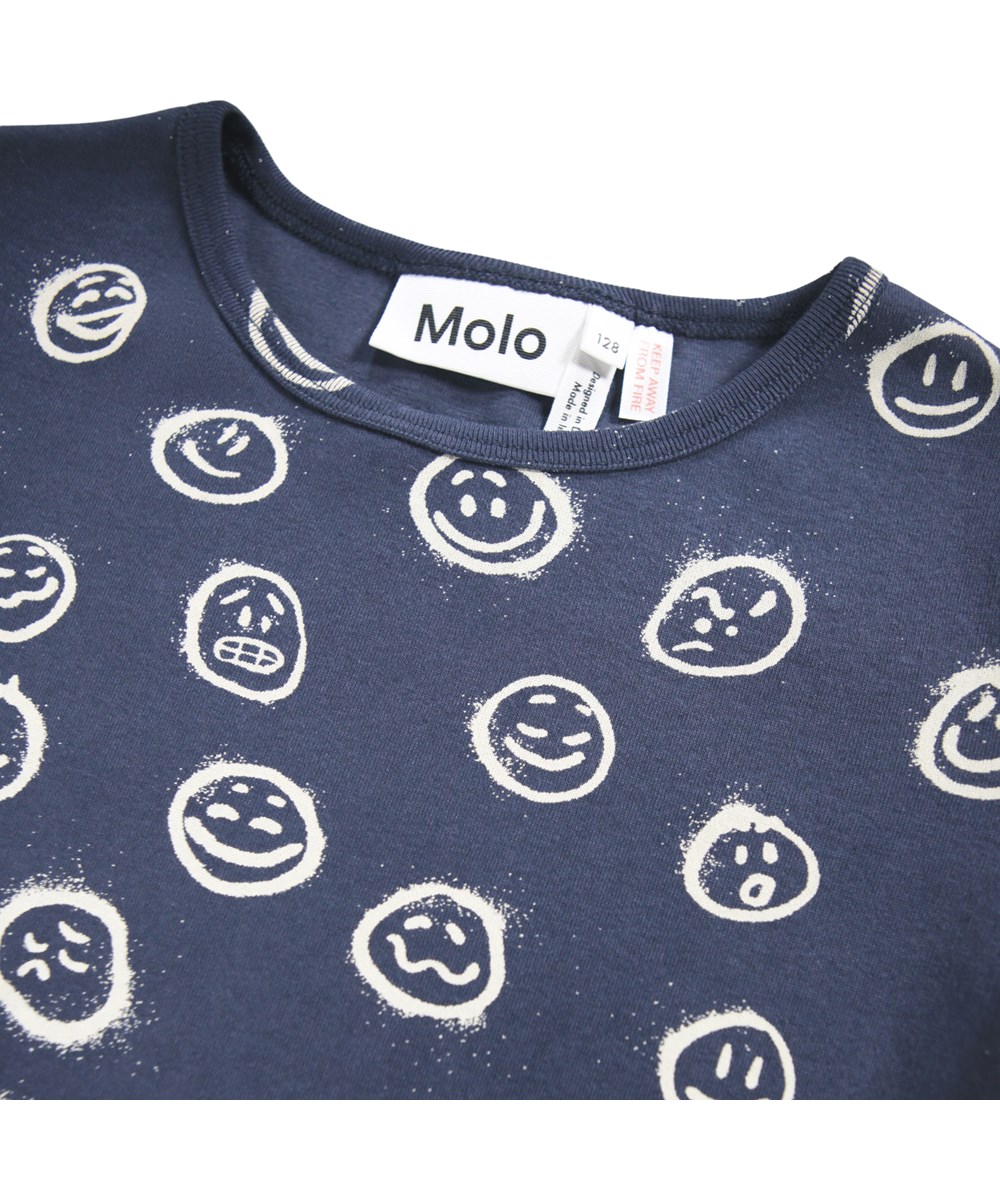 Lue - Galaxy Moods - Mörkblå pyjamasset för barn tillverkat av ekologisk bomull med vita ansikten spraymålade i olika stämningar.