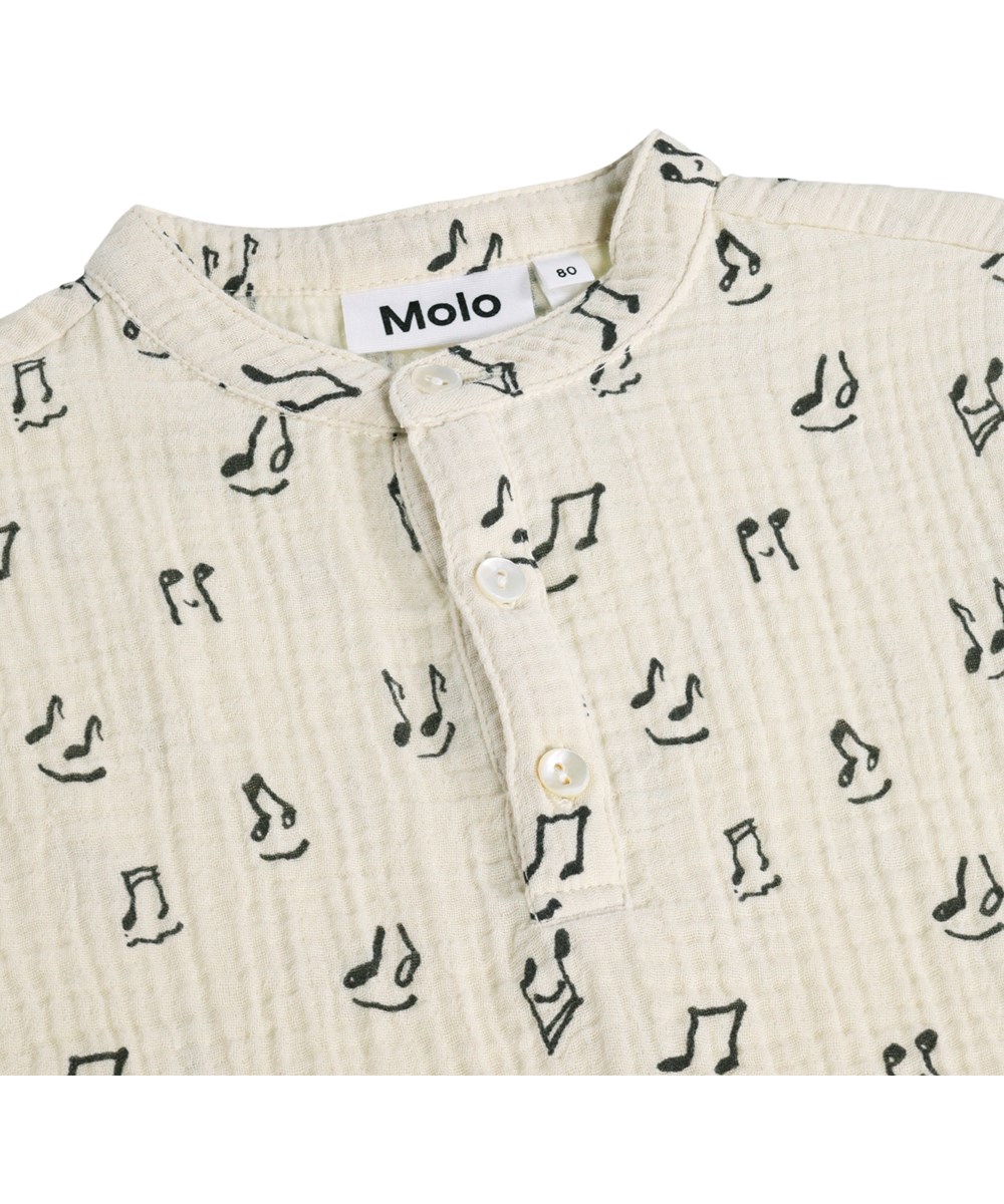 Evero - Happy Notes - Krämfärgad, kortärmad pikétröja för de små i ekologisk bomullsmuslin med musikmönster