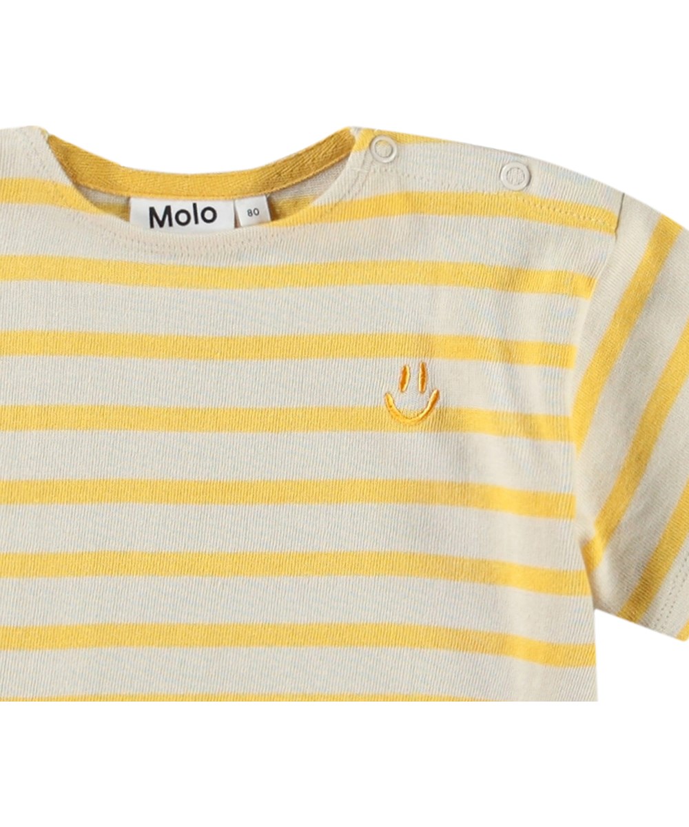 Eivor - Mimosa Stripe - Randig t-shirt i gult och beige med korta ärmar i ekologisk bomull för en baby.