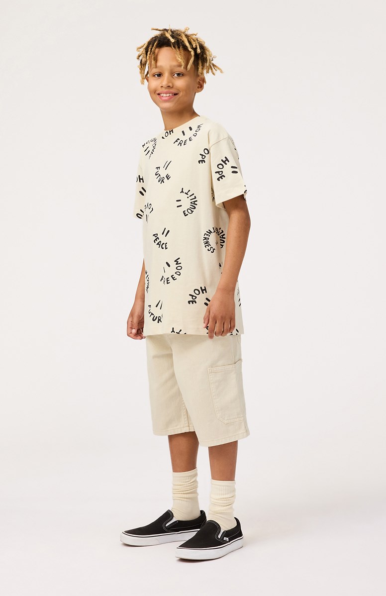 Riley - Smiling Words - Off-white t-shirt med tryck för barn i mjuk ekologisk bomull med korta ärmar och ribbad halsringning.