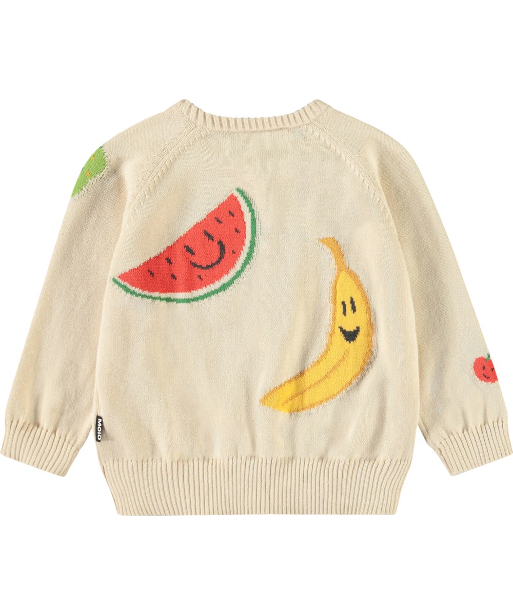 Brody - Cute Fruits - Stickad kofta för baby i mjuk ekologisk bomull. Koftan är beige med glada frukter på.