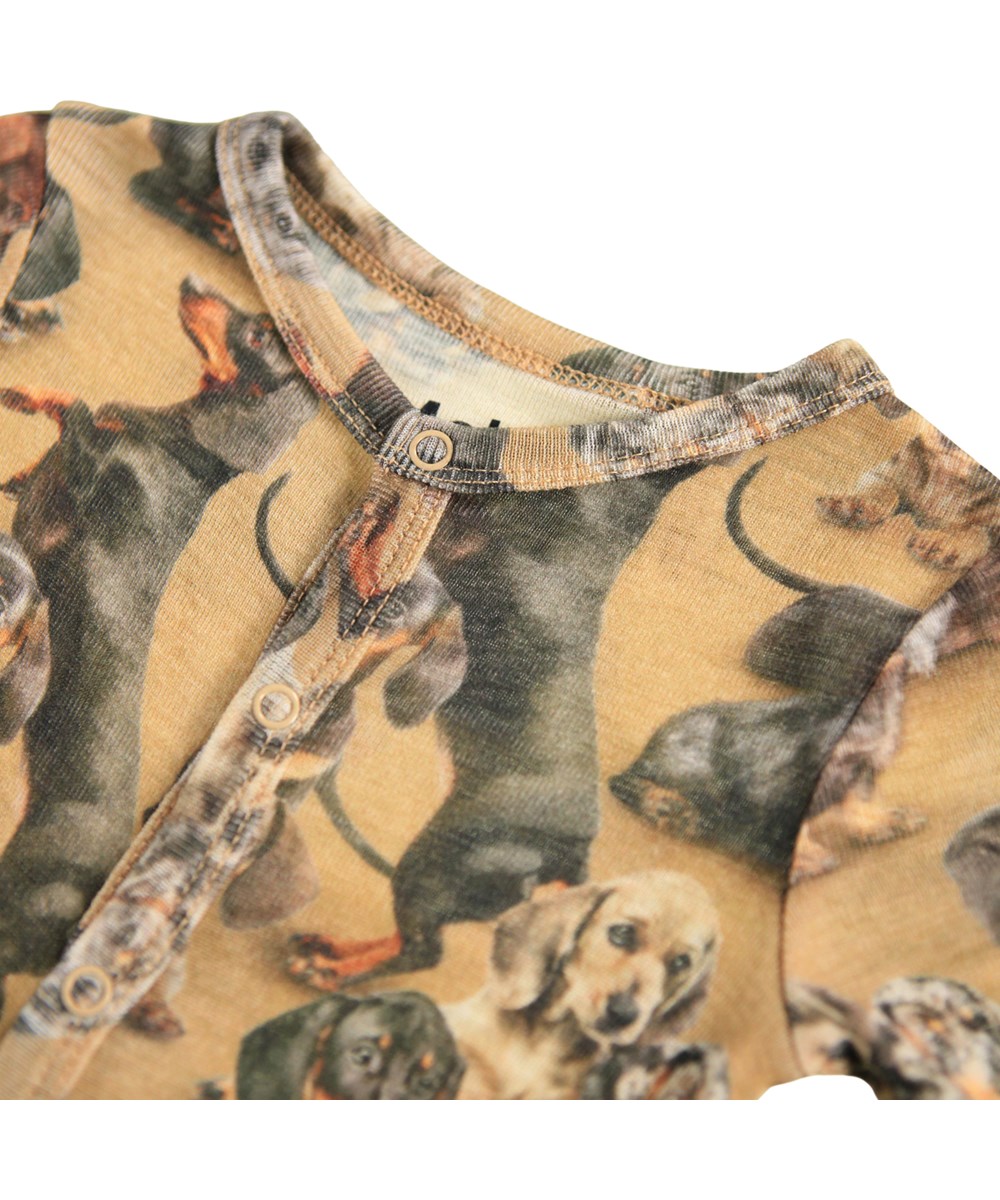 Fahari Wool - Dachshunds - Brauner Baby-Strampler aus Merinowolle mit einem Dackel-Print.