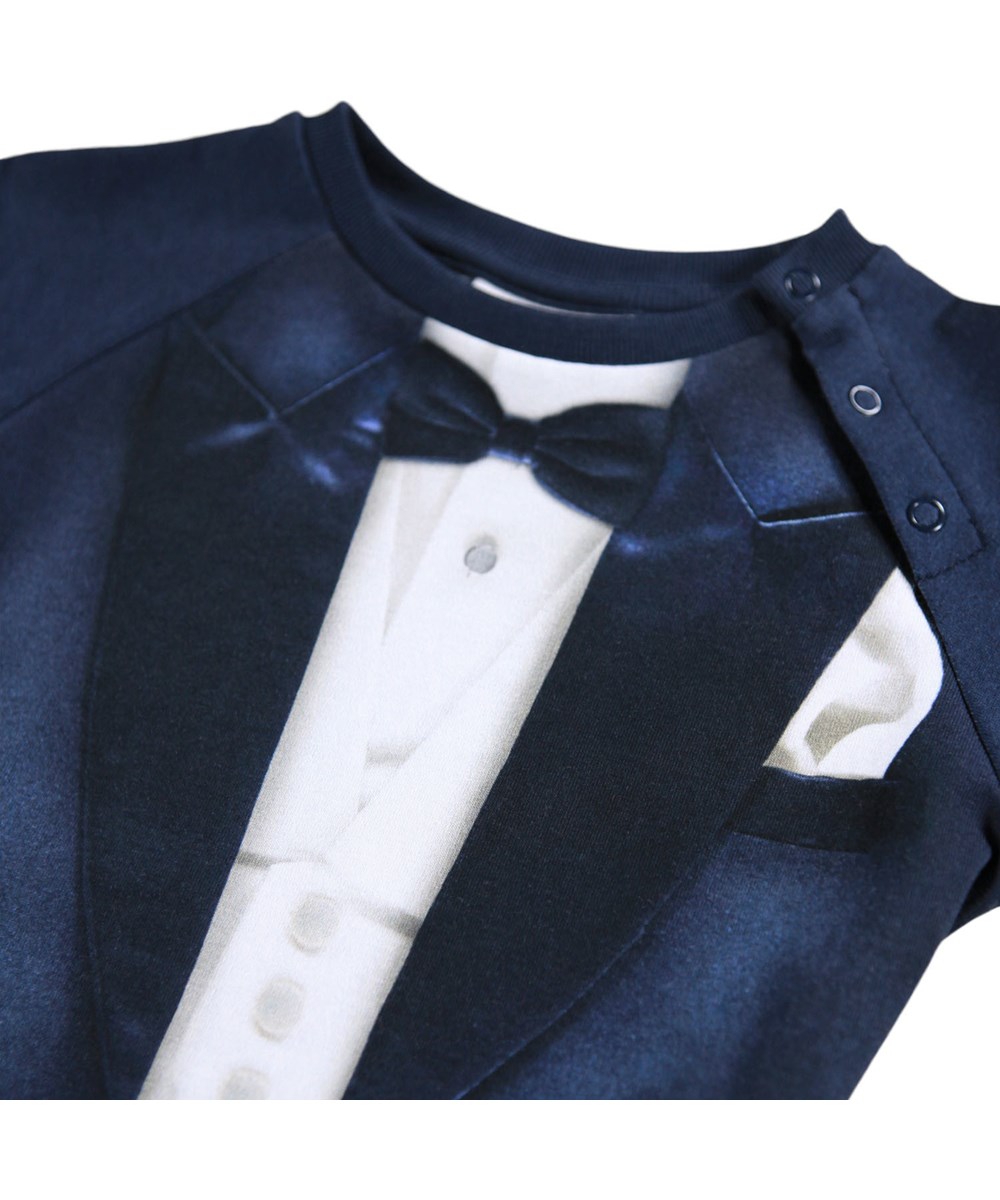 Fairfax - Tuxedo Baby - Blaue Baby-Strampler aus weicher Öko-Baumwolle mit einem Anzug-Print.