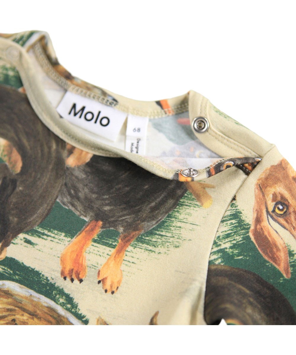 Foss - Painted Dogs - Beige rompertje voor de kleintjes gemaakt van biologisch katoen met lange mouwen en een print van teckels.