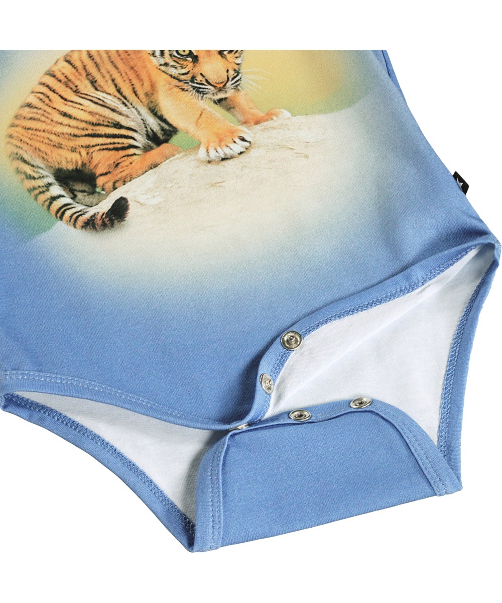 Foss - Tiger Cub - Blauw, lang mouwloos rompertje voor de kleintjes gemaakt van biologisch katoen met een tijgerprint.
