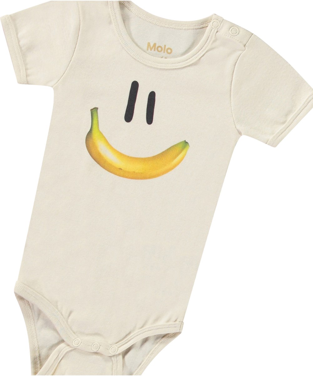Fossie - Babynanas Smile - Babyromper met lang mouwen van biologisch katoen. De romper heeft een print van een smiley met een banaan als mond.