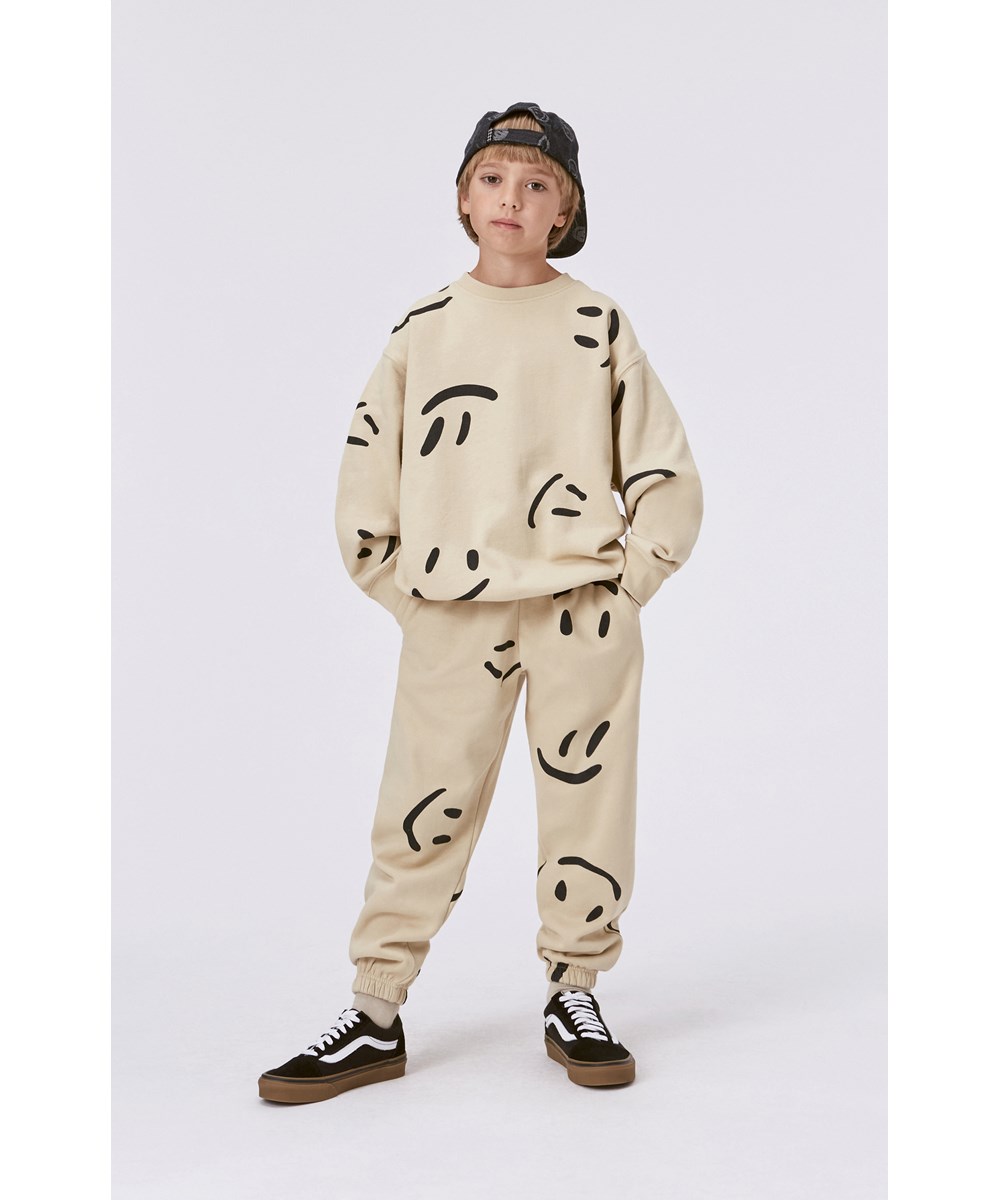Adan - Big Smiles - Beige biologische joggingbroek met grote lachende gezichten print
