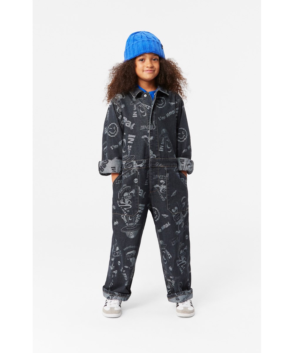 Ayo - Comic Jacquard - Zwarte denim jumpsuit in een ruimvallende pasvorm met levendige stripfiguren.