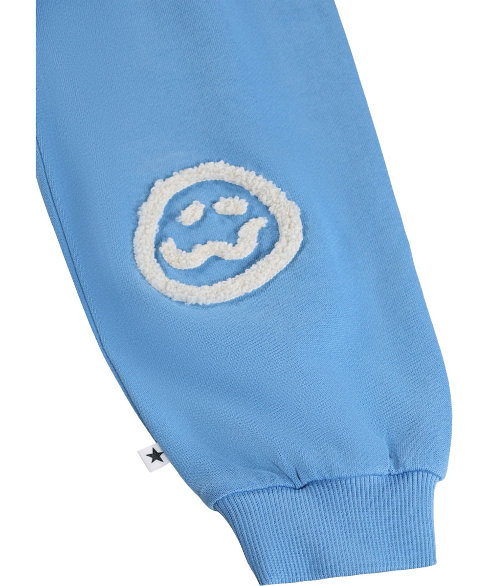 Simeon - Blue Tide - Zachte, blauwe joggingbroek voor de kleintjes gemaakt van biologisch katoen met grappige kniestukken.