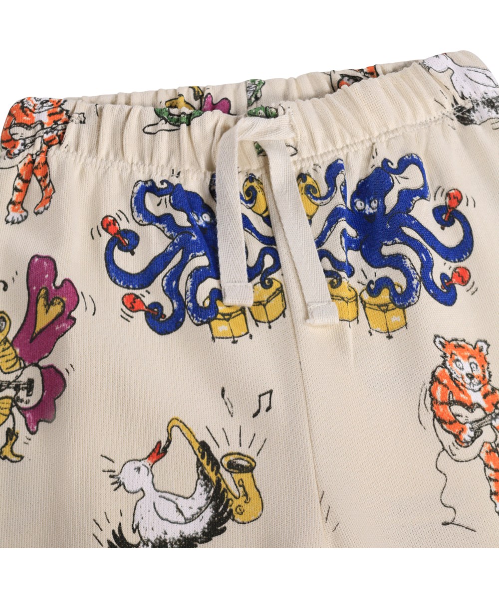 Simeon - Rockin Animals - Zachte, beige joggingbroek voor de kleintjes gemaakt van biologisch katoen met een muziekprint.