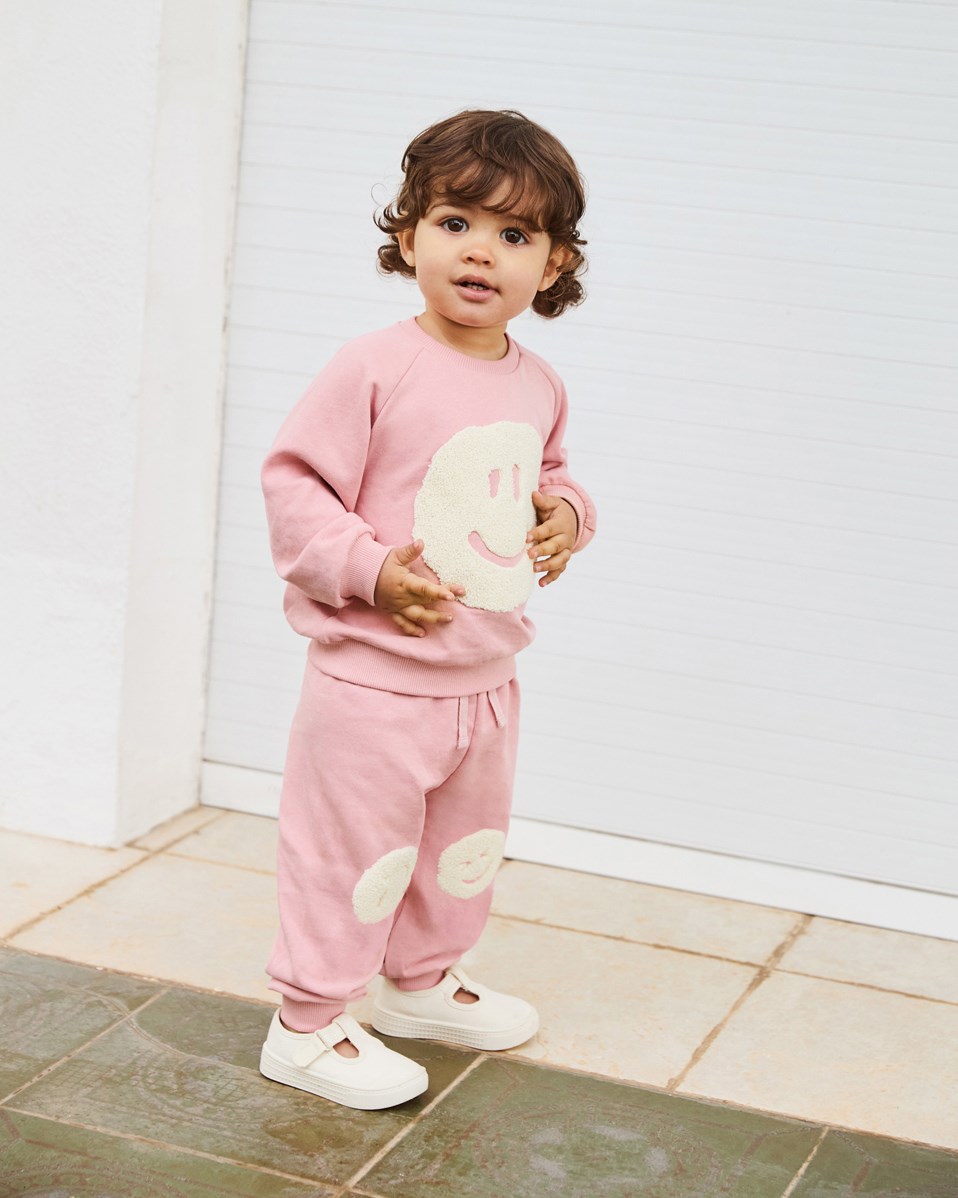 Simeon - Rosequartz - Zachte babybroek van biologisch katoen. De broek is roze met een smileyprint.