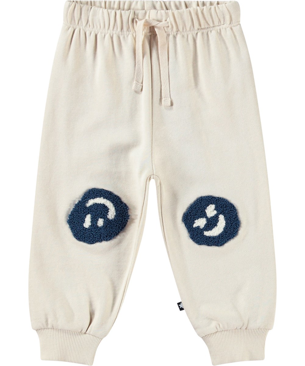 Simeon - Summer Sand - Zachte babybroek van biologisch katoen. De broek is lichtbeige met een smileyprint.
